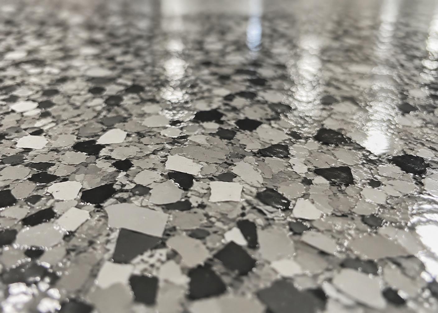 Close-up of a gray and charcoal flake garage floor coating with a high gloss topcoat